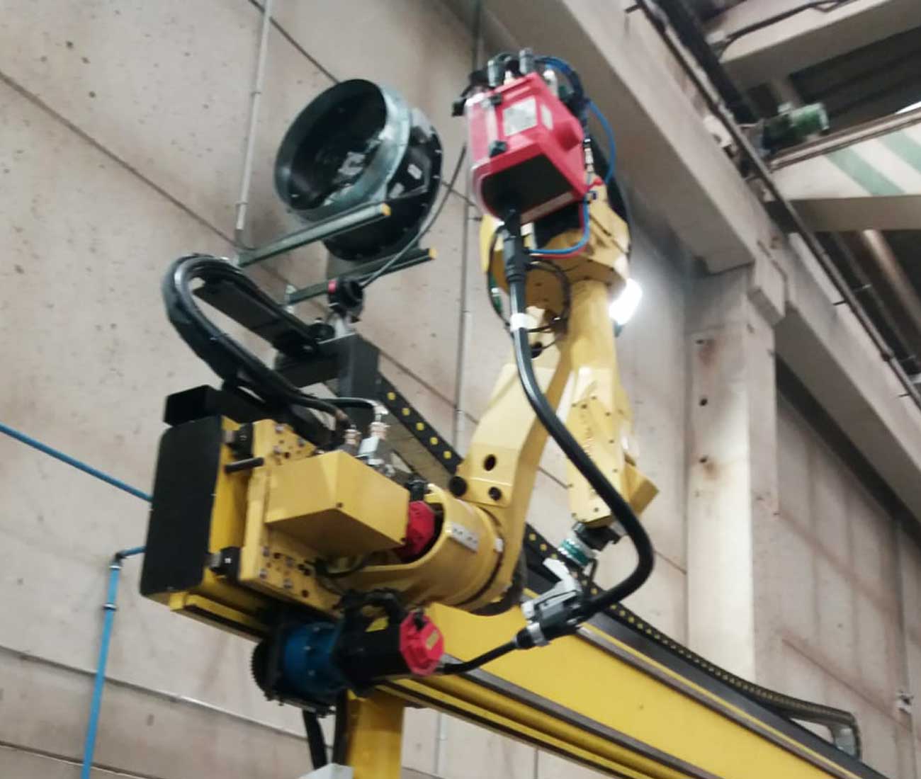 Célula soldadura con robot suspendido por track aéreo